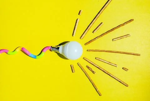 A creative composition of a light bulb and rays of light, a minimalistic conc Foto stock