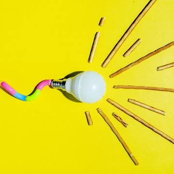 A creative composition of a light bulb and rays of light, a minimalistic conc Foto stock