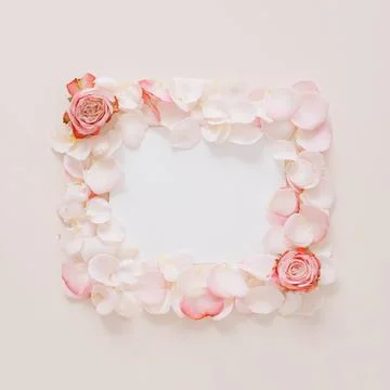 Creative composition made with rose flowers and petals with paper card note. Stock Photos