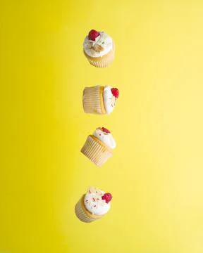 Creative composition. Small appetizing muffins with whipped cream and raspber Stock Photos