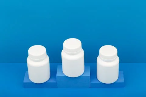 Creative composition with three medication bottles on winner pedestal Stock Photos