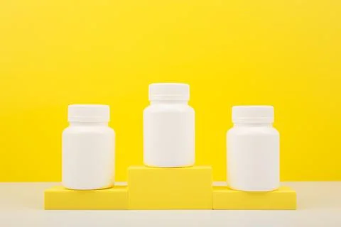 Creative composition with three medication bottles on winner pedestal against Stock Photos