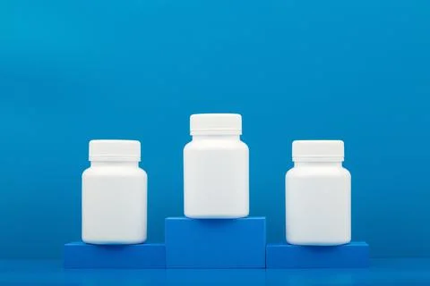 Creative composition with three medication bottles on winner pedestal Stock Photos