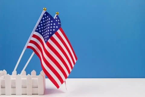 Creative composition with two american flags on white table with blue wall Stock Photos