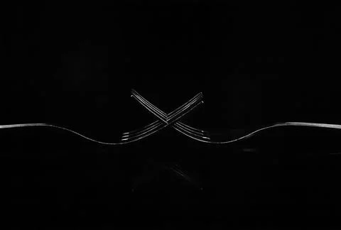 Creative composition of two forks isolated on a black background Stock Photos