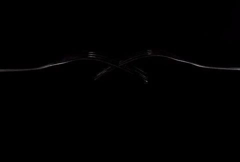 Creative composition of two forks isolated on a black background Stock Photos