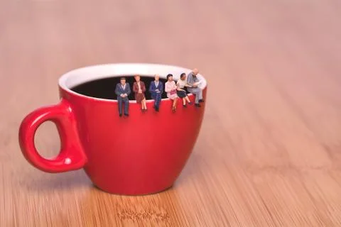 Creative concept about drinking coffee and waiting. Miniature people on the c Stock Photos