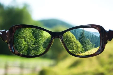 Creative concept about poor vision. Landscape focused in glasses lenses Foto stock