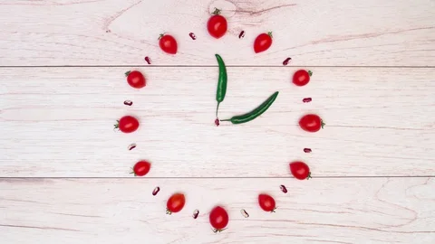 Creative concept of clock, made of tomatoes, pepper and haricot. Stop motion 動画素材 128926680