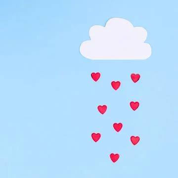 Creative concept of cloud with raining hearts on pastel blue background. Flat Stock Photos