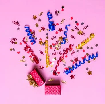 Creative concept with festive decor on pink background. Explosion of confetti Stock Photos