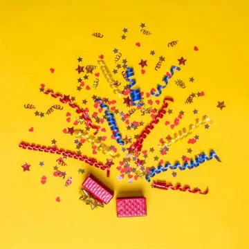 Creative concept with festive decor on yellow background. Explosion of conf.. Stock Photos