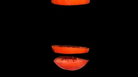 Creative concept with flying tomato. Sliced red tomato isolated on black Video stock 122303081