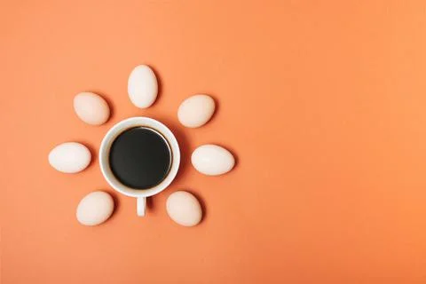 Creative concept made with cup of coffee and eggs on pastel brown orange back Stock Photos