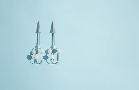 Creative concept made of electric egg beaters and white rose flowers on paste Stock Photos