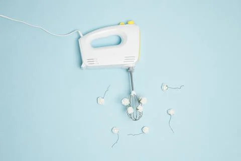 Creative concept made of white electric hand mixer with beaters and white ros Stock Photos