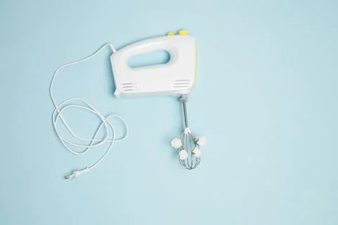 Creative concept made of white electric hand mixer with beaters, cabel and wh Stock Photos