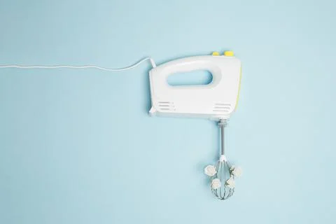 Creative concept made of white electric hand mixer with beaters and white ros Stock Photos