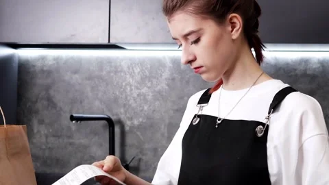 Creative cooking in a modern kitchen with a young chef preparing her dish 스톡 동영상 296315237