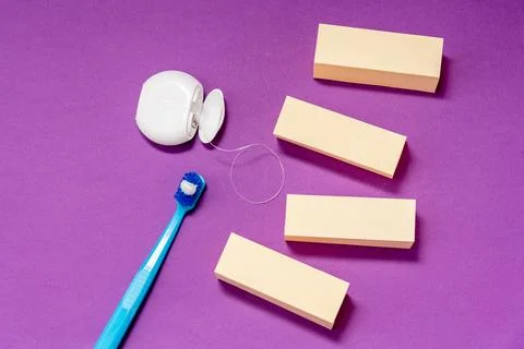 Creative copy text space on purple background with dental floss and toothbrus Stock Photos