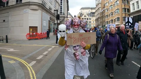 Creative costume stop oligarchs putin London march support ukraine, slow motion Stockbeeldmateriaal 171486447