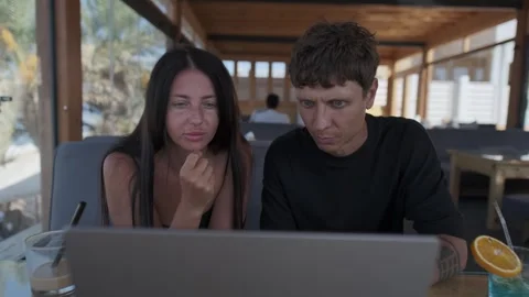 Creative coworkers analyzing project on laptop, discussing problems and Stock Footage 346251279