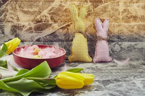 Creative cozy Easter background: handmade bunnies, yellow tulips. Creative Stock Photos