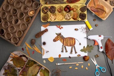 Creative craft project with a zebra paper cut-out, decorated with leaves an.. 스톡 사진