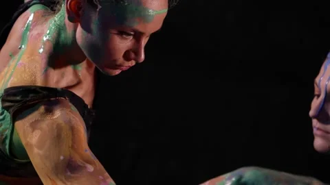 Creative dance with smearing by dyes, two women are dancing together in darkness 動画素材 169695937