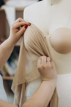 A creative designer is checking a fabric on the mannequin. Stock Photos