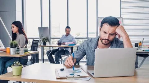 Creative designer get stress while working with laptop at modern office.workp Stock Photos