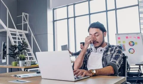 Creative designer get stress while working with laptop at modern office.workp Stock Photos