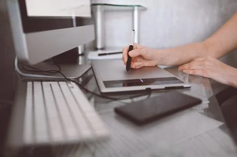 Creative designer hands working on laptop with graphic tablet. Stock Photos