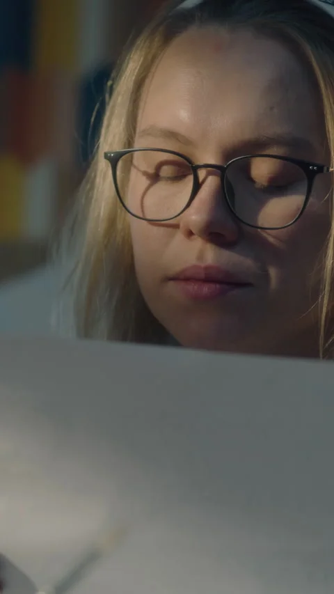 Creative designer takes a critical look at her sketches blows away eraser crumbs Stock Footage 276159528