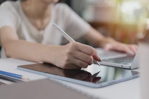 Creative designer working on a graphic tablet with a stylus and laptop. bus.. Foto stock