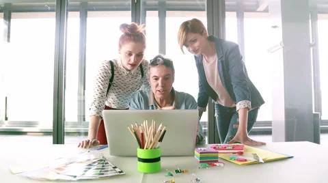 Creative director looking at laptop with his team and discussing plans Stock Footage 59543585
