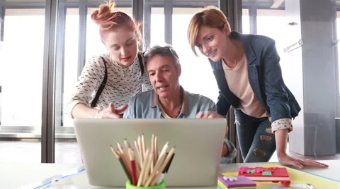 Creative director looking at laptop with his team and discussing plans Stock Footage 59543586