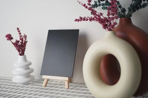 Creative display of decorative vases and an empty canvas 스톡 사진