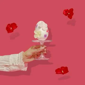 Creative Easter abstract concept. A female hand holds a large white Easter Stock Photos