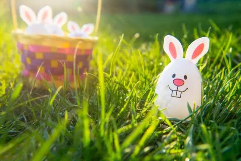 Creative Easter composition of Funny Easter egg with bunny ears on green grass Stock Photos