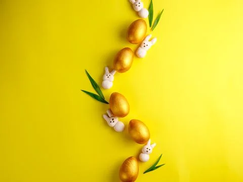 Creative Easter composition made from golden wooden eggs, pink marshmallow bunny Stock Photos