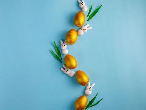Creative Easter composition made from golden wooden eggs, pink marshmallow bu Stock Photos