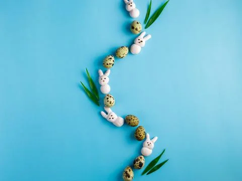 Creative Easter composition made from motley quail eggs, pink marshmallow bun Foto stock