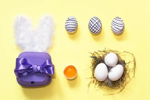 Creative easter composition with painted eggs, violet box and nest Foto stock