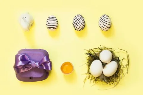 Creative easter composition with painted eggs, violet box and nest 스톡 사진
