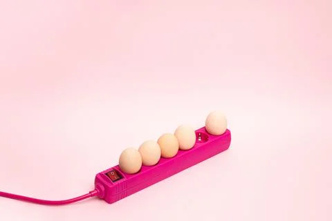 Creative Easter concept with eggs plugs in with extension pink cable. Minimal Stock Photos