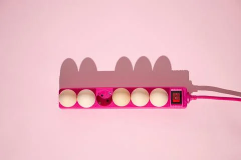Creative Easter concept with eggs plugs in with extension pink cable and shad Stock Photos