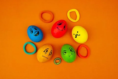 Creative Easter Egg Faces With Fun Expressions On Orange Foto stock
