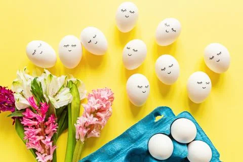 Creative easter eggs with cute face and sleepy eyes on pastel yellow backgrou Stock-Fotos