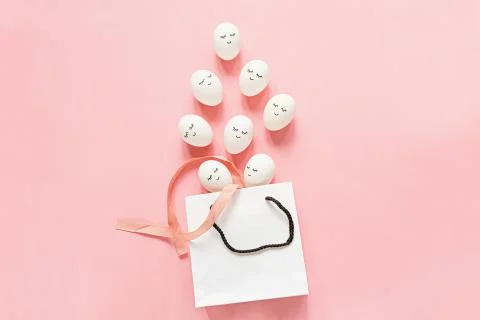 Creative easter eggs with cute face and sleepy eyes and white bag on pastel p Foto stock